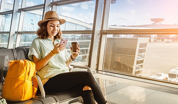 A women looking at her phone at the airport.